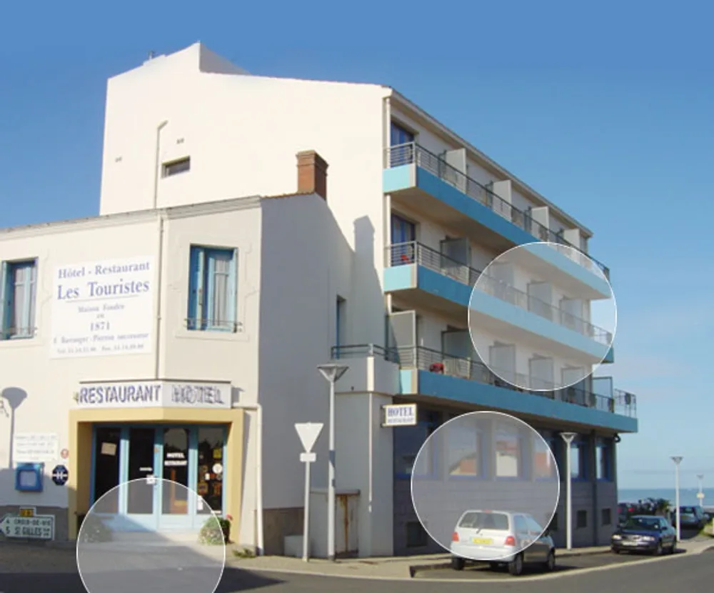 Façade de l'Hôtel-Restaurant Les Touristes, avec ses balcons bleus